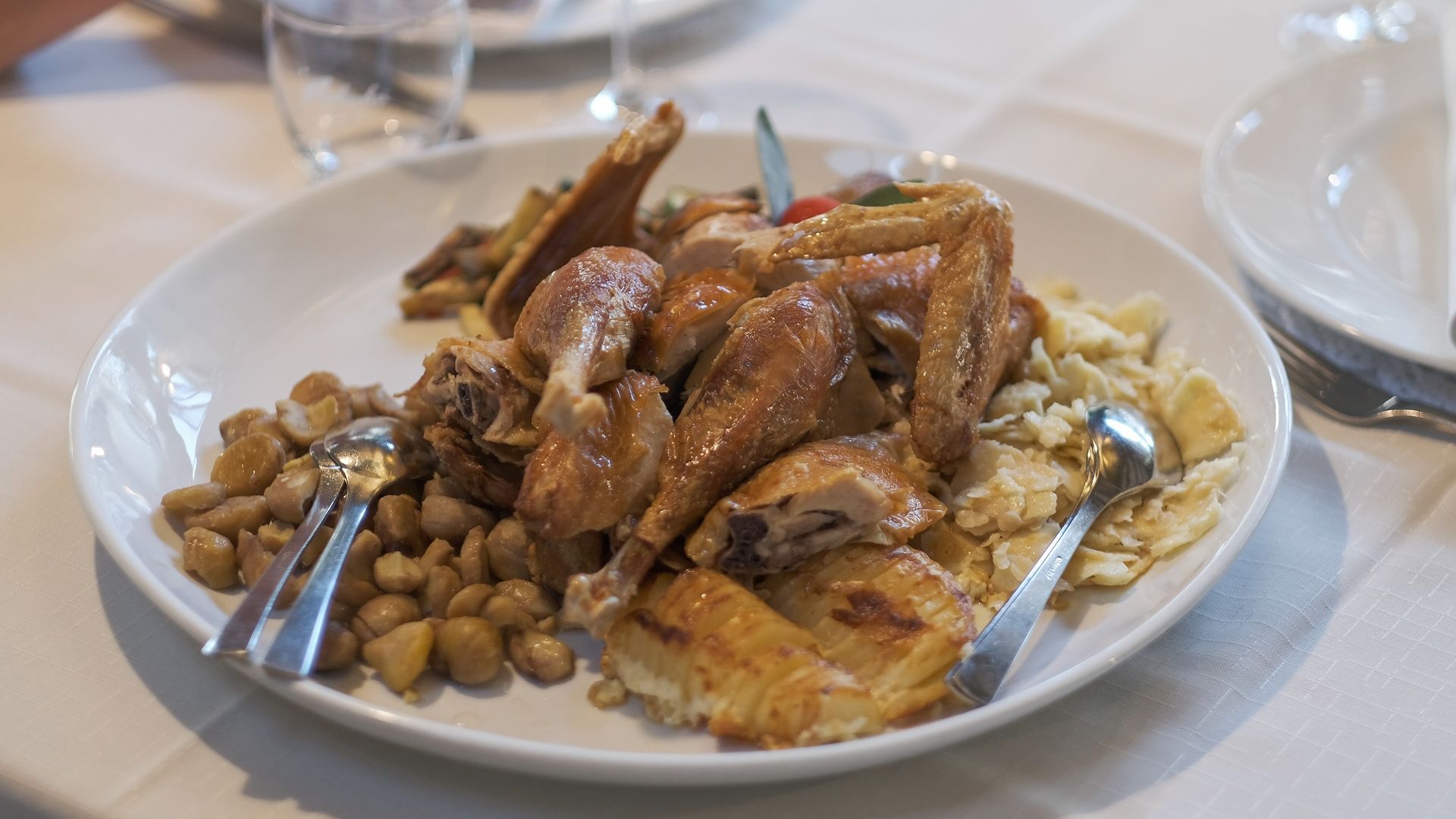 Fotografija piščanca, postreženega na krožniku v restavraciji.