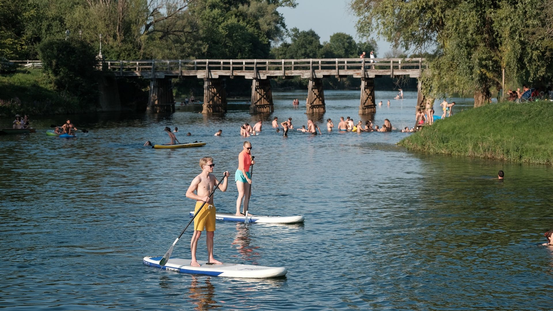 Fotografija ljudi, ki se kopajo v reki Krki.